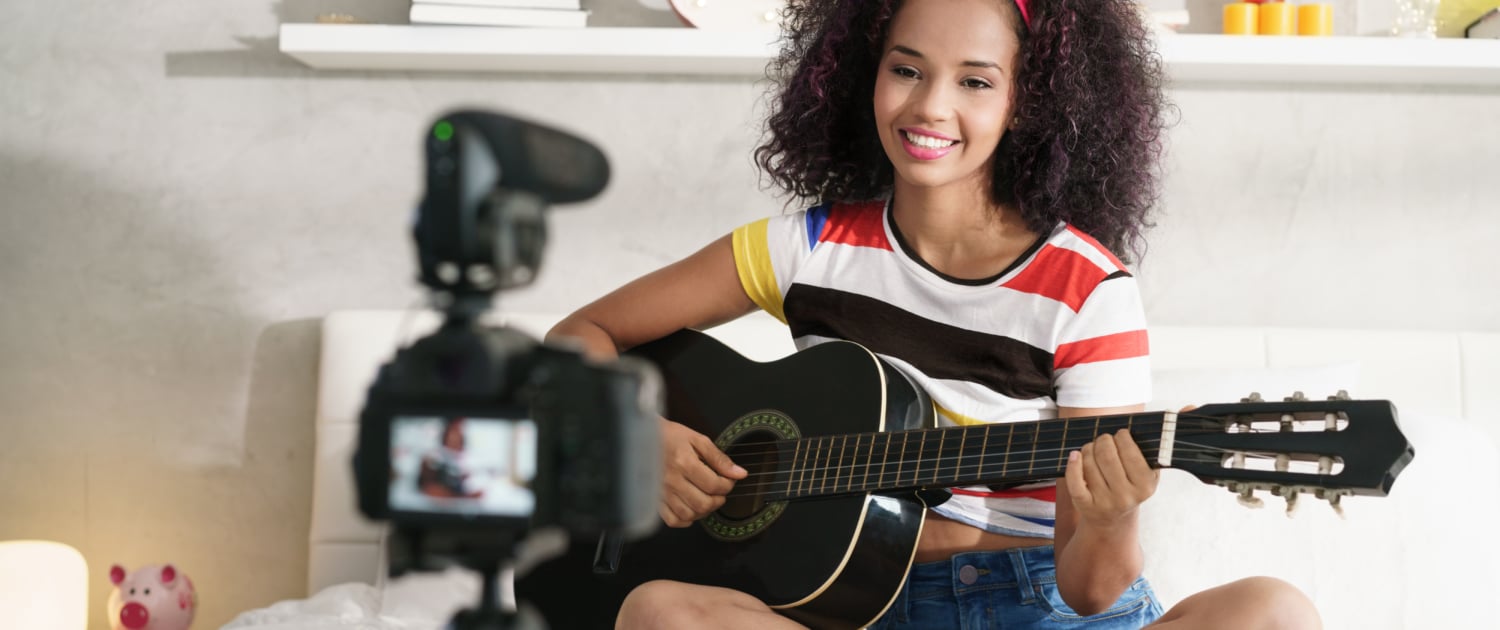 Influencerin spielt Gitarre vor der Kamera