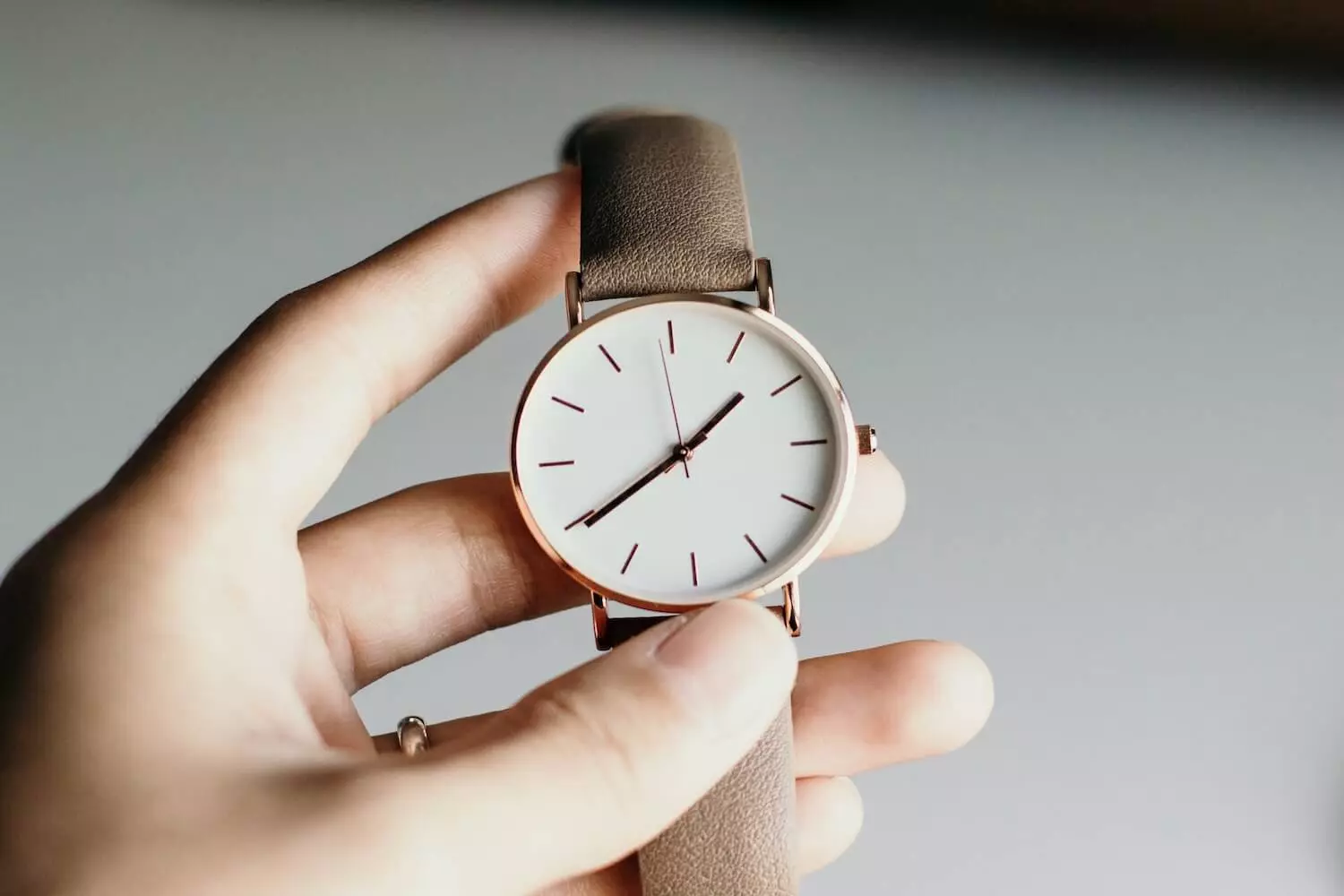 Eine Frau hält eine Uhr in der Hand und kontrolliert die Zeit eines Livestreams.