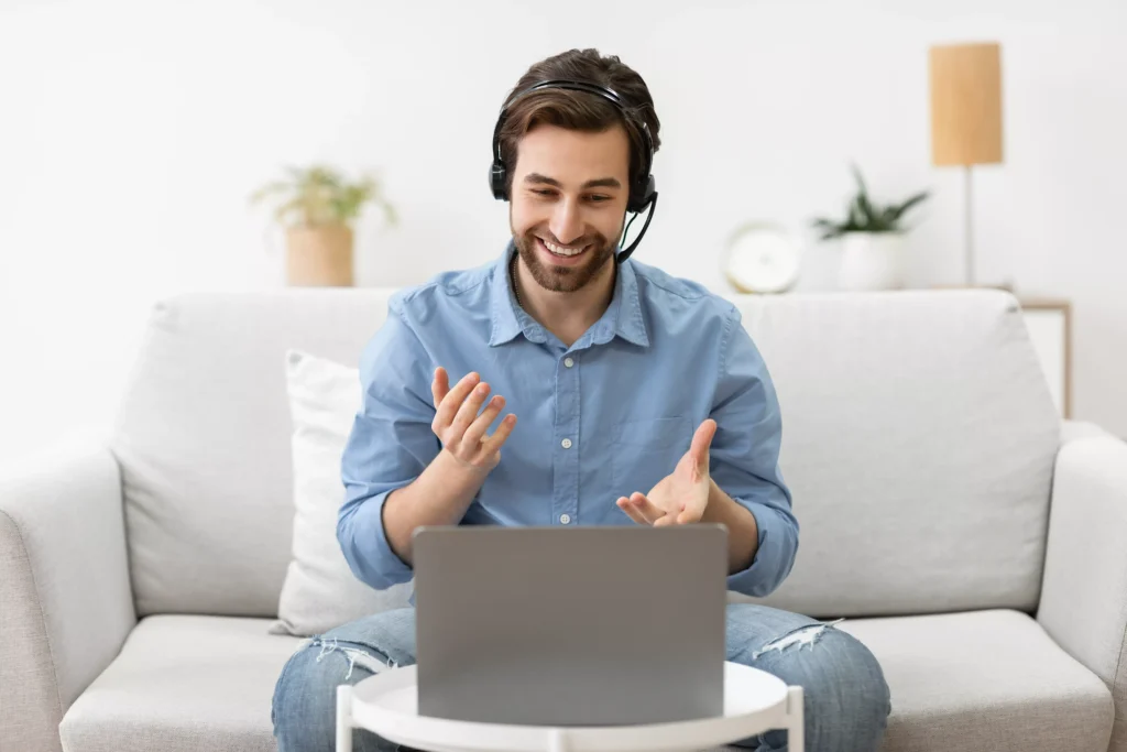 Ein Mann sitzt vor einem Laptop und folgt einem Webinar oder einem Webcast.