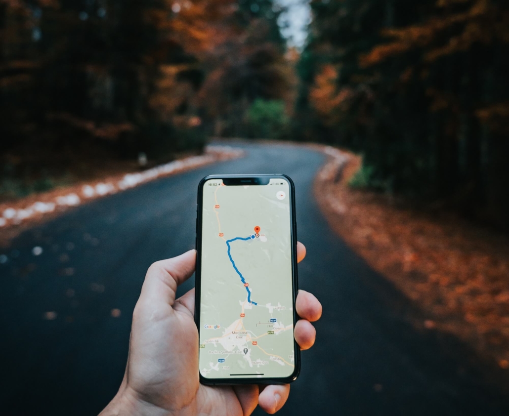 Ein Smartphone navigiert den Weg durch einen Wald.