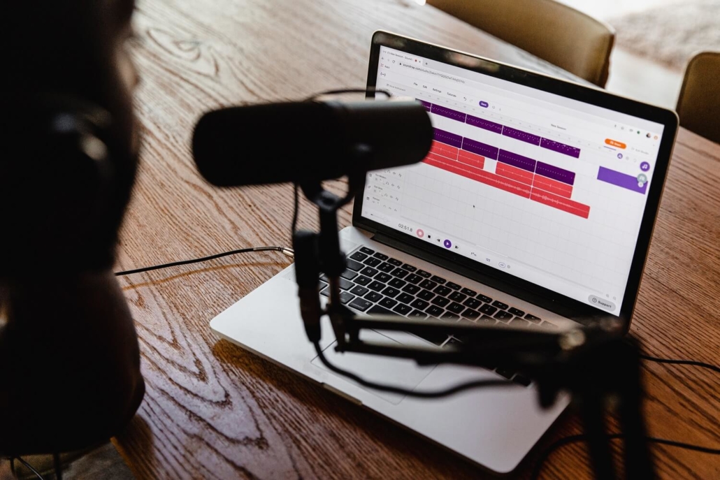 Aufnahme des Podcasts mit einem Mikrofon und einem Laptop.