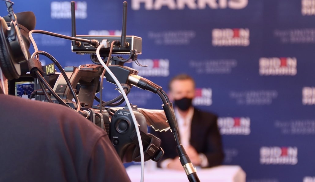 Ein Mann wird während einer Livestream Pressekonferenz gefilmt