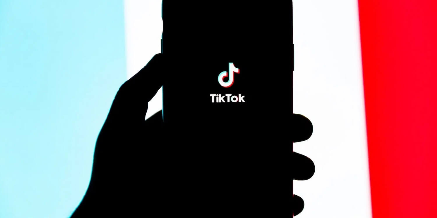 Eine Hand hält ein Smartphone, um einen Blick auf die neuesten TikTok Trends zu werfen.