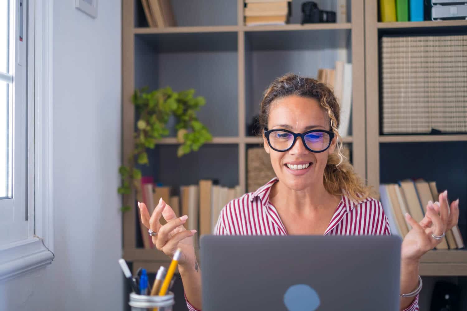 Eine Frau sitzt vor einem Laptop und informiert sich über Call-to-Action Arten.