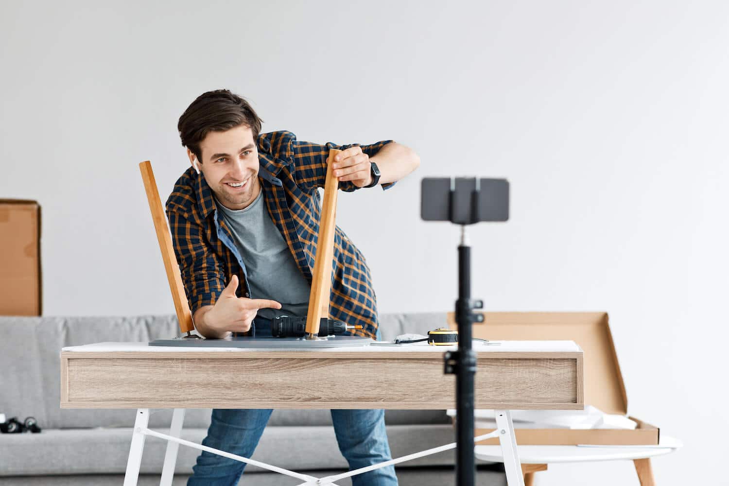 Ein Mann erstellt eine Videoanleitung und demonstiert, wie man einen Stuhl aufbaut.