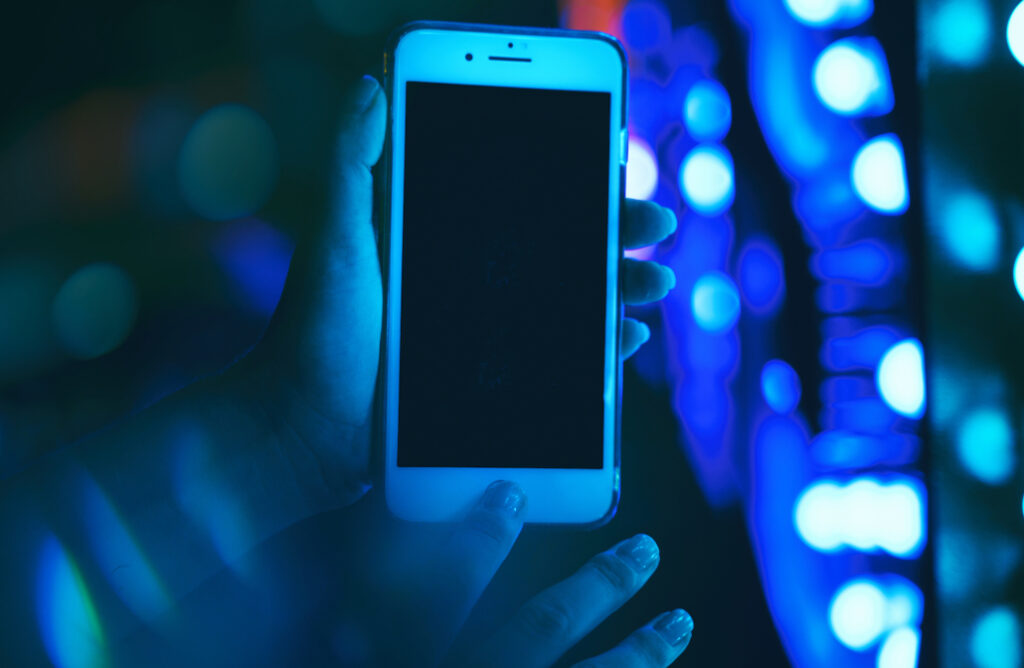 Die Hand einer Frau zeigt den Display eines iPhones, mit dem Livestreams gemacht werden können