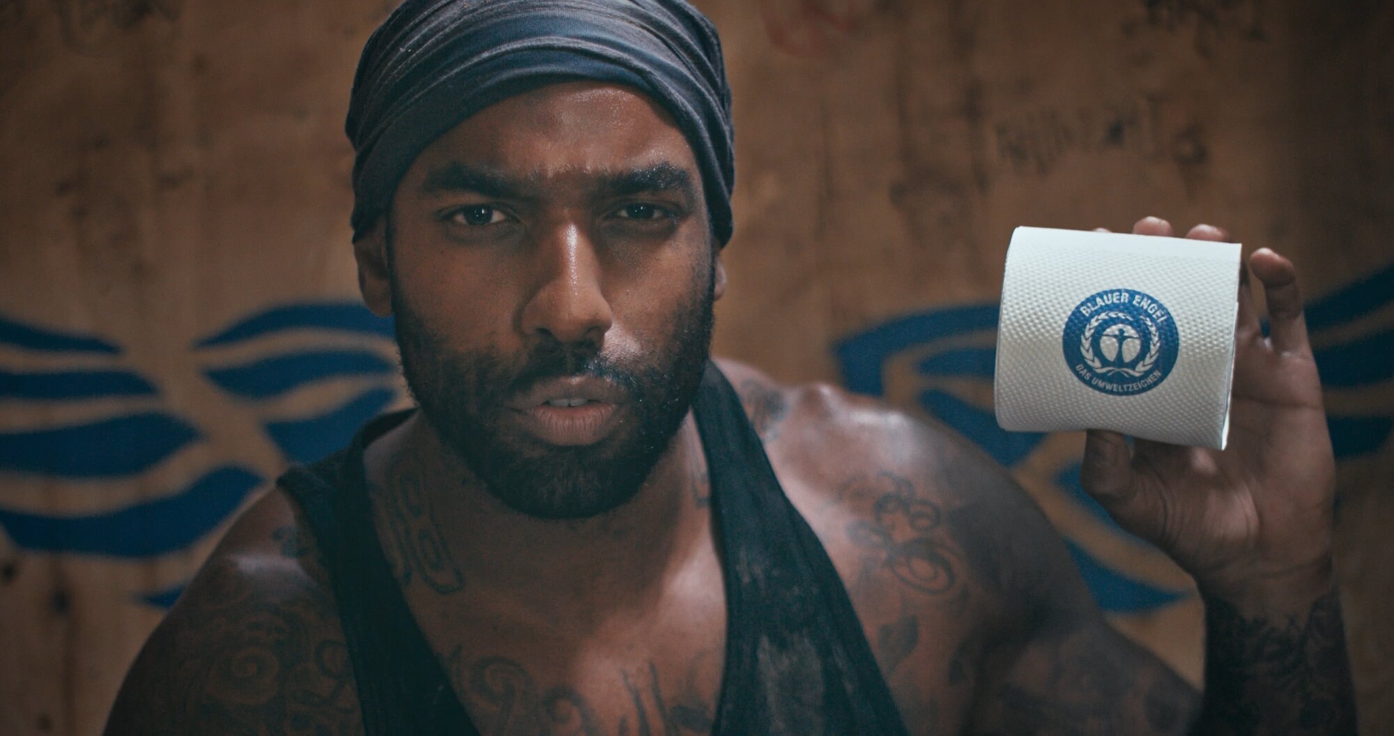 Eine Szene aus einem Produktvideo Beispiel zeigt einen Mann mit einer Toilettenpapier-Rolle auf einer Festival-Toilette.